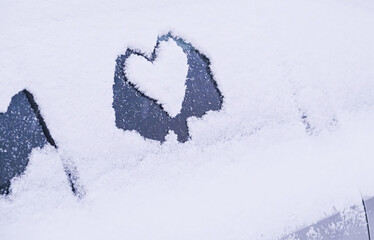 heart shape drawn on snowy car window winter love symbol