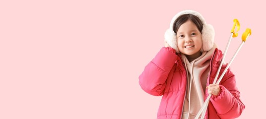 Happy little Asian girl with ski poles on pink background with space for text