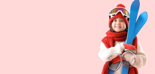 Little Asian girl with skis on pink background with space for text