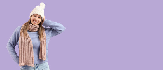 Young woman in winter clothes on lilac background