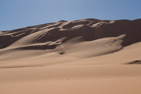 Majestic sand dunes under clear blue sky in Libyan desert