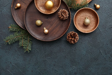 Beautiful table setting with Christmas balls, cones and fir branches on dark background