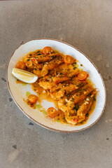 Close-up photo of a dish with large shrimps decorated with spices