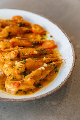 Close-up photo of a dish with large shrimps decorated with spices