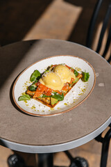 Toast with eggs benedict red fish and spinach. Breakfast lunch and dinner in a restaurant
