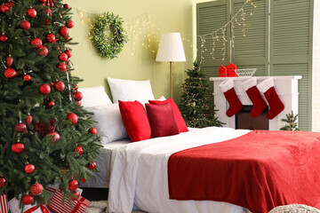 Interior of bedroom with Christmas trees and fireplace