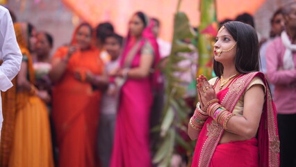 Women doing namaskar to Sun God at sunrise during Chhath Puja.
