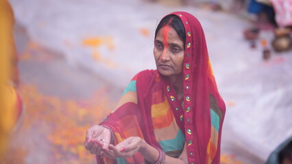 Devotee woman standing in holy water offering prayers during Chhath Puja morning ceremony, symbolizing faith and spiritual purity.