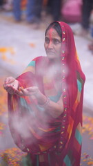 Indian woman standing in sacred water during Chhath Puja sunrise, holding offerings and praying with devotion and peace.