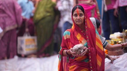 Women offering coconuts while standing in holy water during Chhath Puja sunrise ritual, showing devotion, peace, and spiritual faith.