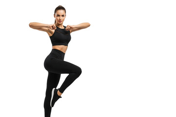 Fototapeta premium A woman in a black sports bra and leggings striking a pose with her fists raised, against transparent background