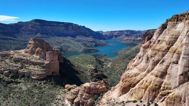 Aerial view of the Apache Trail showcasing the rugged terrain and shimmering Canyon Lake nestled amidst the arid landscape, Apache Junction, Arizona, United States.