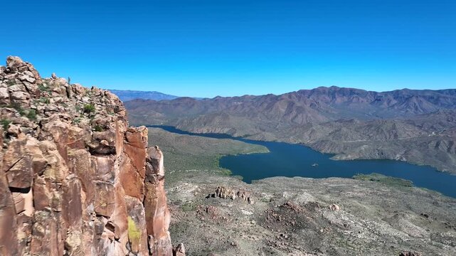Aerial view of Canyon Lake's tranquil waters winding through the rugged terrain along the Apache Trail, framed by Arizona's arid beauty, Apache Junction, Arizona, United States.
