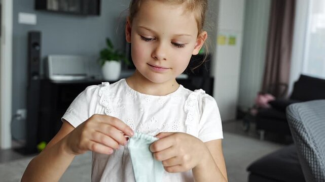 Little girl placing her baby tooth into a small pouch for the tooth fairy. Capturing a tender childhood ritual filled with imagination and meaning.