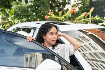 Young woman driver looking thoughtful in car
