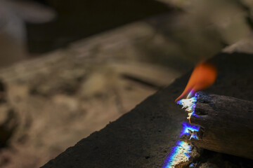 Intense heat from burning wood shows close up of blue and orange flame. This powerful detail of combustion and raw energy creates powerful abstract background of fire