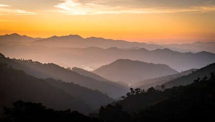 Obraz premium Serene mountain landscape at sunset with layered hills and misty valleys under a colorful sky