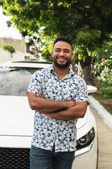 Confident man smiling standing next to new car