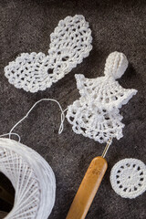 Close-up photo of crocheting a delicate white lace angel. Handmade eco-friendly Christmas...