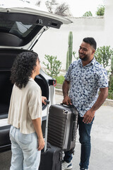 Couple packing luggage into suv for road trip