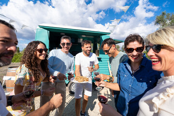 Friends enjoying food and wine at summer food truck party
