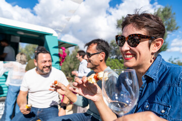 Friends enjoying food and drinks at outdoor food truck party