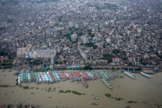 Aerial view of the vibrant Sadarghat Boat Terminal bustling with colorful boats against the backdrop of dense urban sprawl, Dhaka, Dhaka Division, Bangladesh.