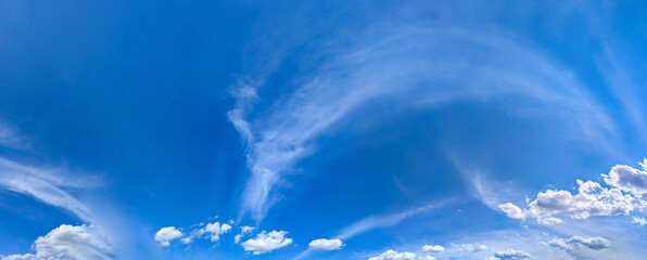 Panorama blue sky with white fluffy clouds. Copy space on panorama of cumulus and cirrus arc clouds...