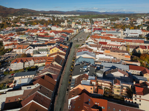 Aerial view of orange rooftops cascading down to a central square, where the buildings and the Holy Trinity Column stand proudly, Banska Bystrica, Banska Bystrica Region, Slovakia.