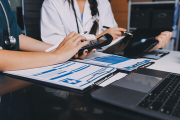 Group of doctors attending seminar in hospital lecture hall with senior physician giving medical...