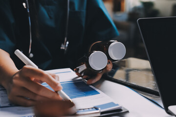 Group of doctors attending seminar in hospital lecture hall with senior physician giving medical...