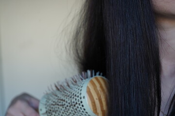 Girl combing her hair with a comb
