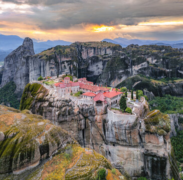 Aerial view of the monasteries perched atop towering rock formations under a dramatic sky, a blend of shadow and light, Meteora, Kalabaka, Trikala, Greece.