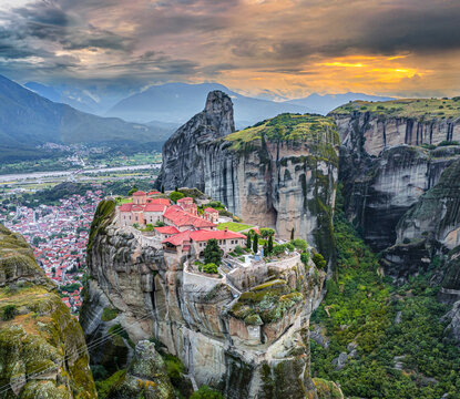 Aerial view of the monasteries perched atop towering rock formations, bathed in the soft glow of the setting sun, creating a serene and majestic scene, Kalabaka, Trikala, Greece.