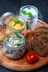 Pates in assortment are arranged in jars. Liver paste. Slices of rye bread. Healthy breakfast.Spectacular serving of dish.