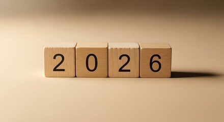 Wooden blocks with black numbers forming the year 2026 on a beige background.
