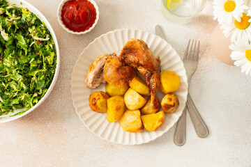 A delicious meal featuring roasted rabbit paired with golden-brown potatoes creates a hearty main course. Accompanying the dish are vibrant chickpea buns and a fresh salad