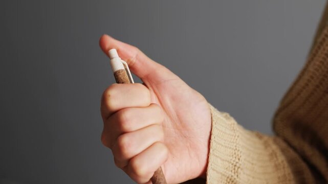 A person grips a marker, suggesting an intention to create or write. The background is neutral, emphasizing the action of marking or drawing