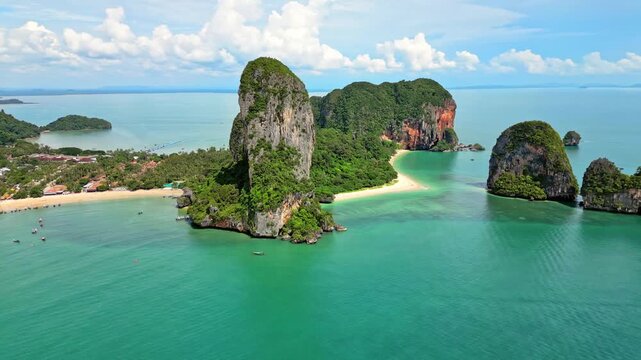 Aerial view of Railay Beach's towering karst cliffs and turquoise waters, a vibrant contrast against the white sand, Ao Nang, Krabi, Thailand.