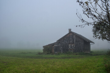 Nebel an einer einsamen Holzhütte
