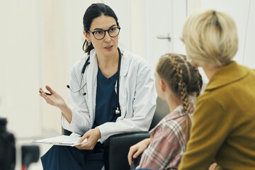 Caucasian female doctor explaining medical information to Caucasian middle aged woman and Caucasian...