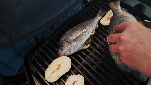 Fresh bream fish on bbq, stuffed with lemon and dill. Outdoor barbecue cooking in summer, seafood grill.
Patatoes with garlic.