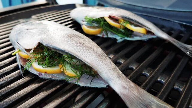 Fresh bream fish on bbq, stuffed with lemon and dill. Outdoor barbecue cooking in summer, seafood grill.
Patatoes with garlic.
