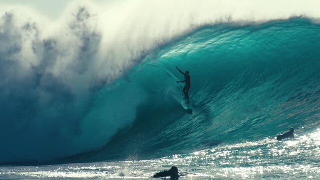 Thrilling Surfer Riding a Massive Blue Ocean Wave.
