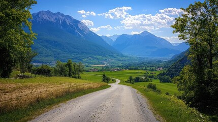 Fototapeta premium Winding gravel road leads to scenic mountain valley.