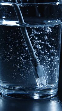 水中に走るダークグレーのイーサネットケーブル：影と光の反射
