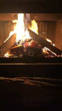A Lit Fireplace on a Winter Evening in a Mountain House. Italian Alps. Vertical Video