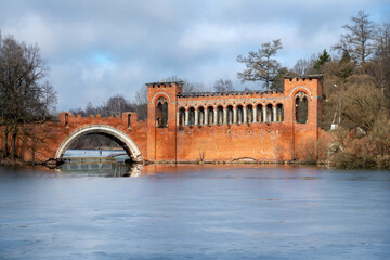 The Red (or Knight's) two-arched pseudo-Gothic bridge spans the channel between two large ponds in...