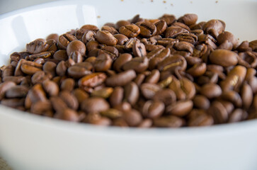 Macro Shot of Dark Roasted Coffee Beans Piled High in a White Bowl