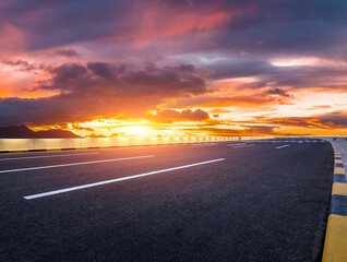 Empty asphalt road and colorful sky clouds at sunset